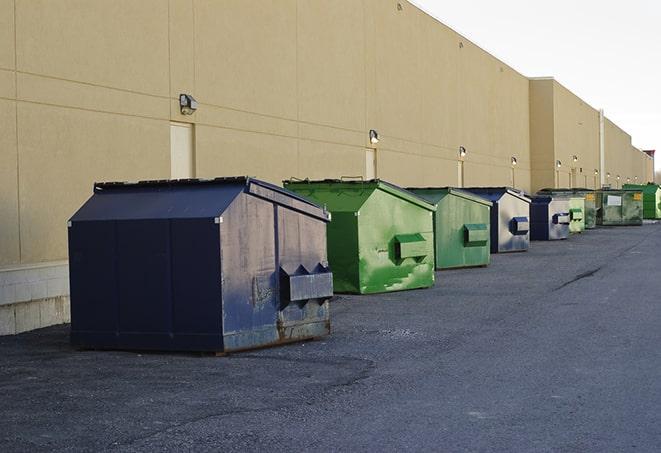 construction workers toss wood scraps into a dumpster in Auburn, WA